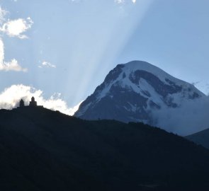 Večerní pohled na kostel Gergeti a Kazbek